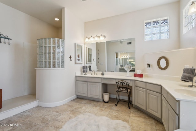 bathroom with baseboards, walk in shower, and vanity