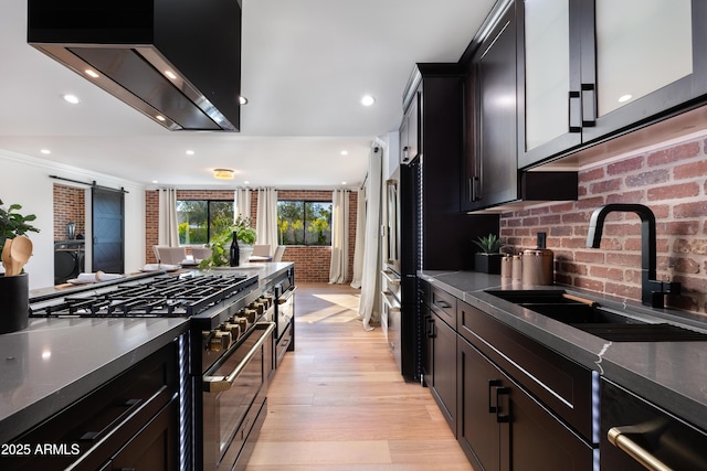 8708 E Rancho Vista Dr, Scottsdale, AZ 85251 - kitchen featuring appliances with stainless steel finishes, exhaust hood, dark countertops, light wood-style floors, and recessed lighting