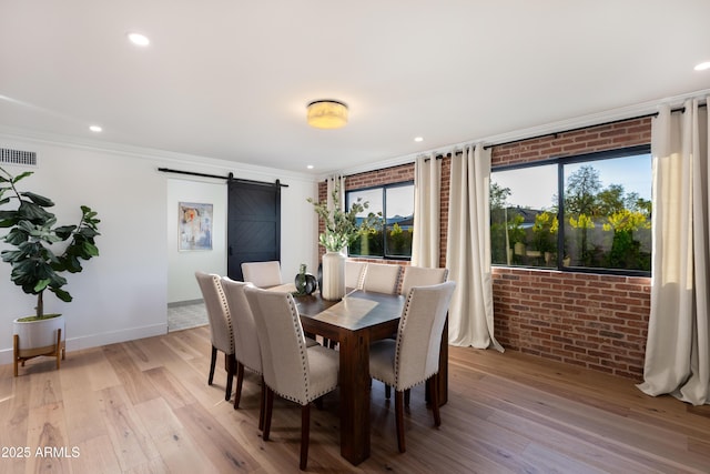 8708 E Rancho Vista Dr, Scottsdale, AZ 85251 - dining room with a barn door, ornamental molding, light wood-style floors, recessed lighting, and brick wall