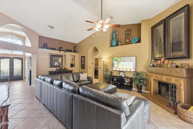 living room with ceiling fan, light tile patterned floors, high vaulted ceiling, and french doors