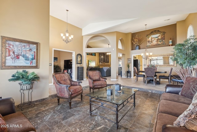 living room featuring high vaulted ceiling and an inviting chandelier