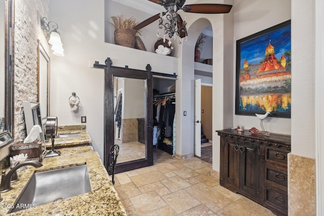 bathroom featuring a high ceiling, vanity, and ceiling fan