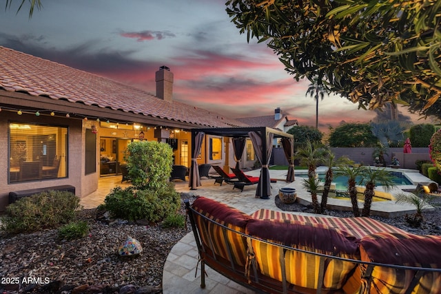 patio terrace at dusk featuring a fenced in pool