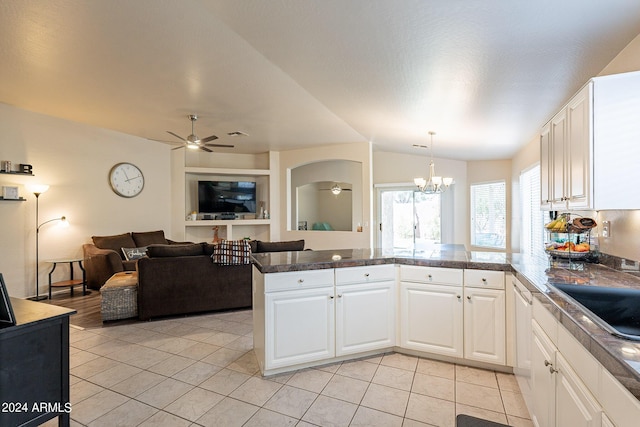 kitchen with kitchen peninsula, white cabinetry, light tile patterned floors, and hanging light fixtures