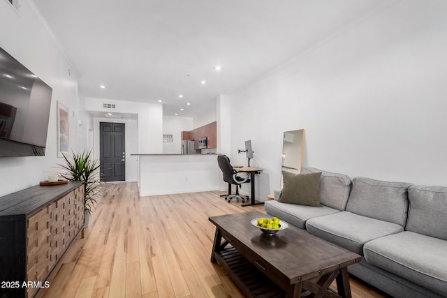 living room featuring crown molding and light hardwood / wood-style flooring