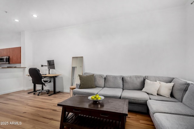 living room with crown molding and light wood-type flooring