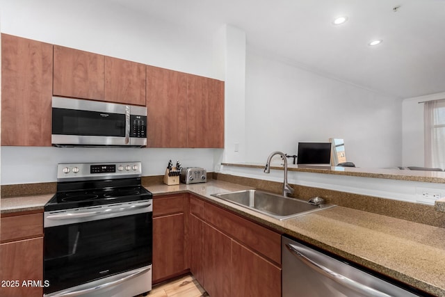 kitchen featuring stainless steel appliances, sink, and kitchen peninsula