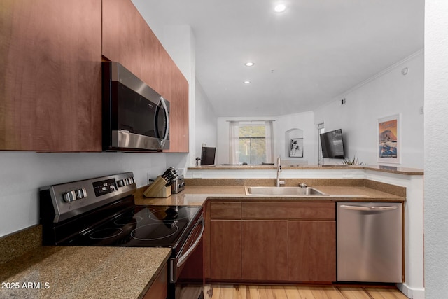 kitchen featuring appliances with stainless steel finishes, sink, and light hardwood / wood-style flooring