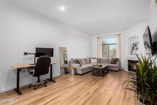 office featuring a fireplace, ornamental molding, and light hardwood / wood-style floors