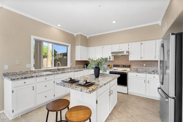 kitchen featuring light stone countertops, white appliances, under cabinet range hood, a sink, and a center island