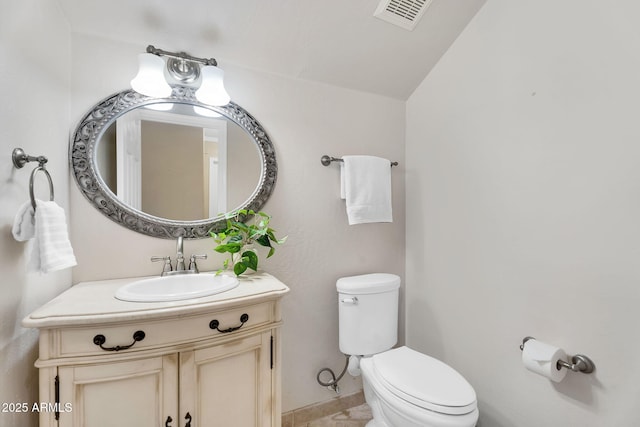 bathroom with visible vents, toilet, and vanity