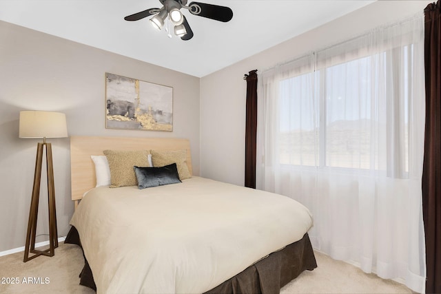bedroom featuring a ceiling fan, light carpet, and baseboards