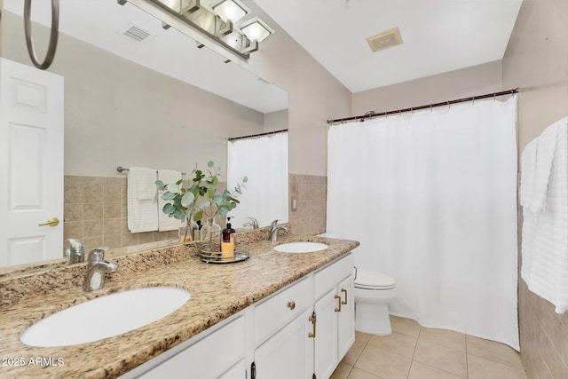 bathroom featuring tile walls, visible vents, tile patterned flooring, and a sink