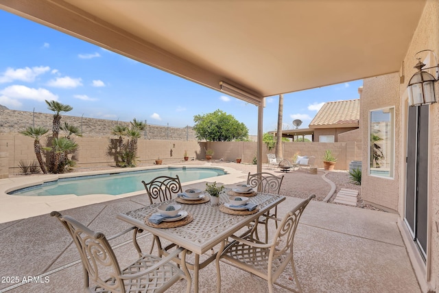 view of swimming pool with outdoor dining area, a fenced in pool, a fenced backyard, and a patio area