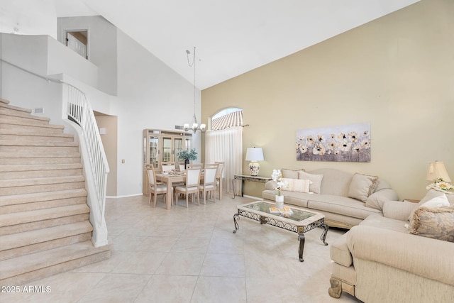 living room featuring stairway, a chandelier, light tile patterned floors, baseboards, and high vaulted ceiling