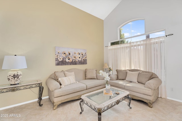 tiled living room with high vaulted ceiling and baseboards