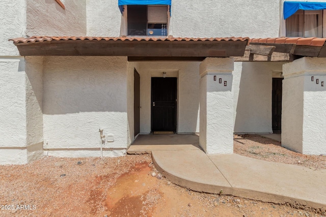2121 W Union Hills Dr Unit 113, Phoenix, AZ 85027 - view of exterior entry with a tiled roof and stucco siding