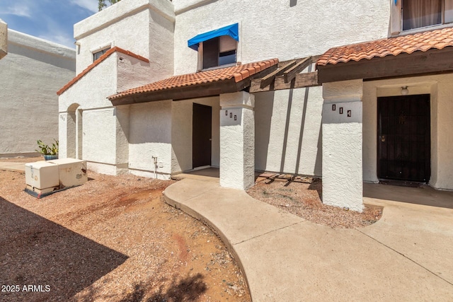 2121 W Union Hills Dr Unit 113, Phoenix, AZ 85027 - view of exterior entry featuring a tiled roof and stucco siding