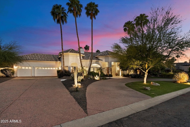 11331 E Cochise Dr, Scottsdale, AZ 85259 - mediterranean / spanish-style house featuring concrete driveway, stucco siding, a tile roof, and a garage