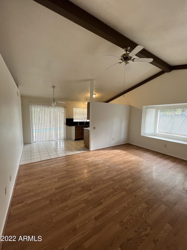 1770 E Sandra Ter, Phoenix, AZ 85022 - unfurnished living room featuring ceiling fan, lofted ceiling with beams, and light hardwood / wood-style flooring
