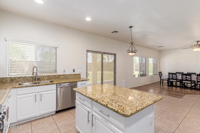 kitchen featuring pendant lighting, stainless steel dishwasher, sink, white cabinetry, and ceiling fan