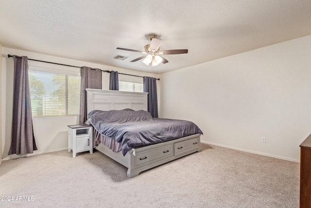 carpeted bedroom with a textured ceiling and ceiling fan