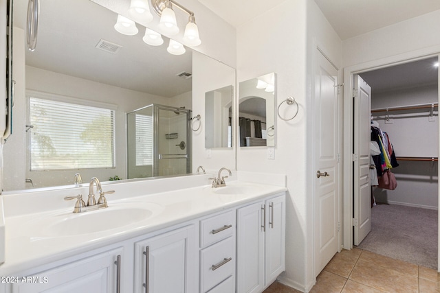 bathroom featuring tile patterned floors, a shower with door, and vanity