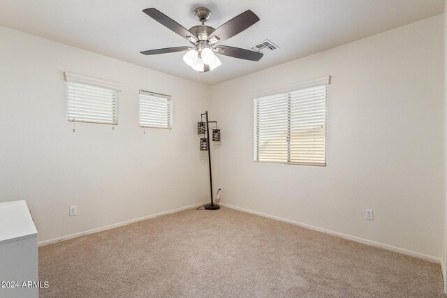 carpeted spare room featuring ceiling fan