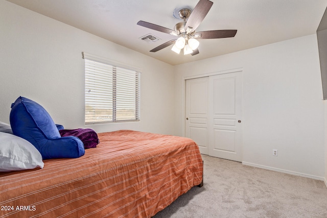 carpeted bedroom featuring ceiling fan and a closet