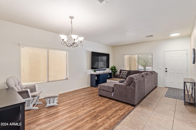 living room with light wood-type flooring and a notable chandelier