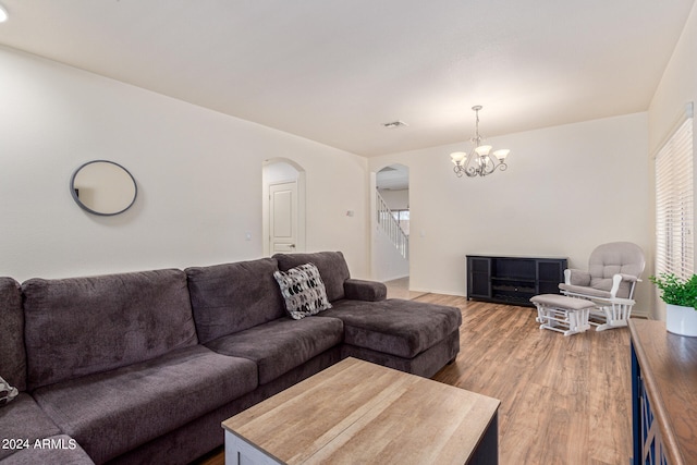 living room featuring a fireplace, hardwood / wood-style floors, and a notable chandelier