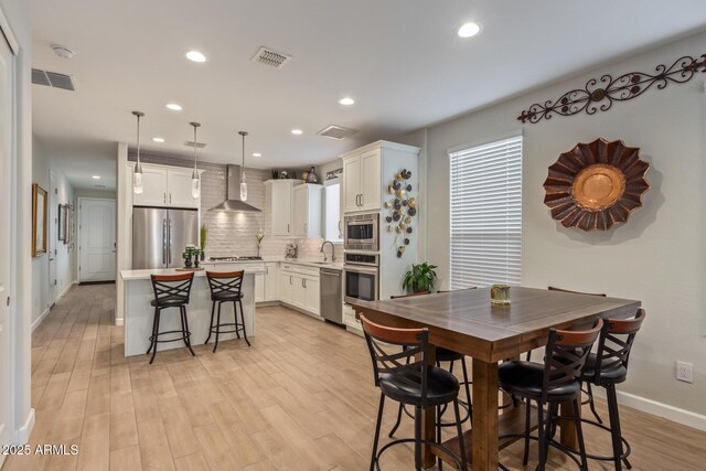 dining space featuring sink and light hardwood / wood-style flooring