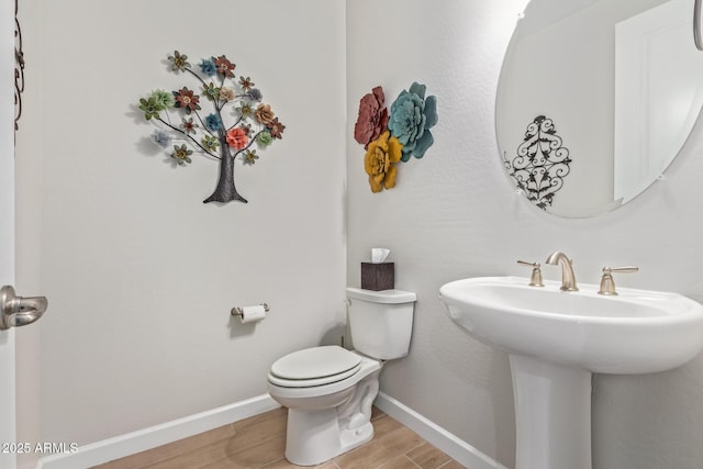 bathroom with sink, toilet, and hardwood / wood-style floors