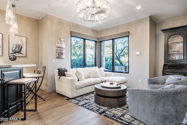 living room featuring recessed lighting, a notable chandelier, and wood finished floors