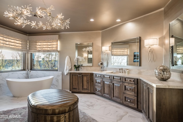 bathroom featuring vanity, crown molding, a tub, and a healthy amount of sunlight