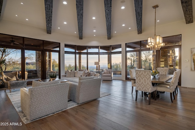 living room featuring hardwood / wood-style flooring, beamed ceiling, and a notable chandelier