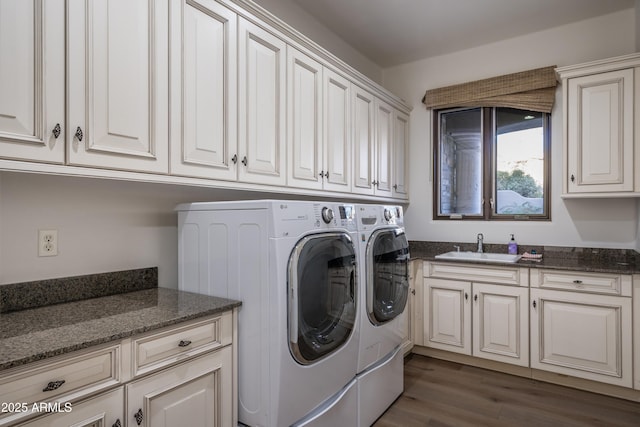 laundry area featuring dark hardwood / wood-style flooring, sink, washer and clothes dryer, and cabinets