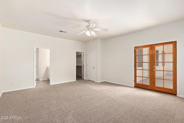 unfurnished bedroom with light carpet, connected bathroom, and a walk in closet