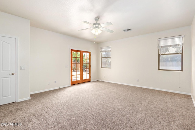 unfurnished room with light colored carpet, french doors, and ceiling fan