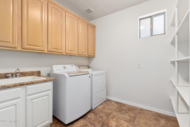 laundry room featuring cabinets, independent washer and dryer, and sink