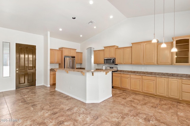 kitchen featuring a kitchen island, a breakfast bar, light brown cabinetry, hanging light fixtures, and stainless steel appliances