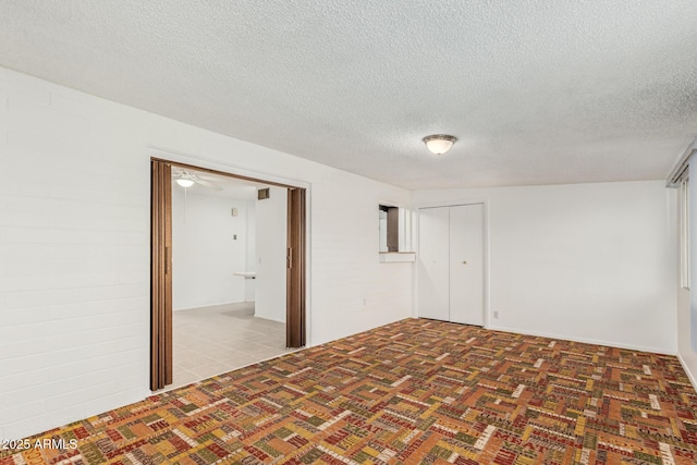 carpeted empty room featuring a textured ceiling