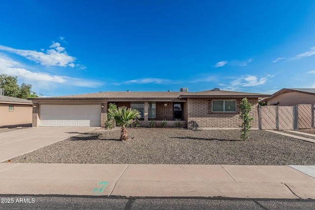 ranch-style home featuring an attached garage, concrete driveway, a gate, and brick siding