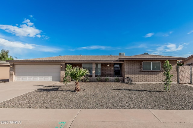 single story home with concrete driveway, a garage, and brick siding