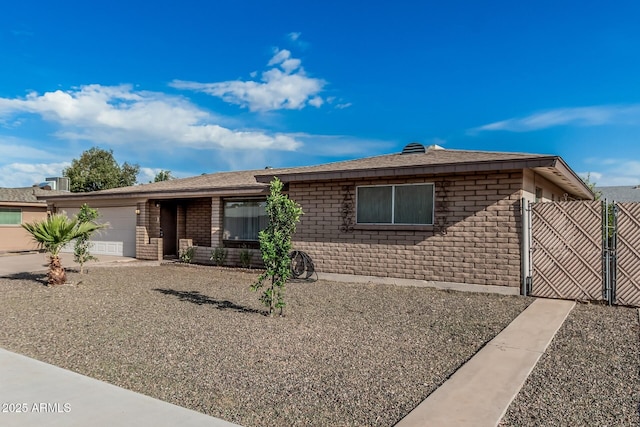 ranch-style house with a garage, brick siding, and a gate