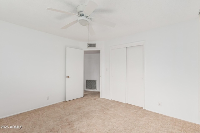 unfurnished bedroom with visible vents, a ceiling fan, carpet flooring, and a closet