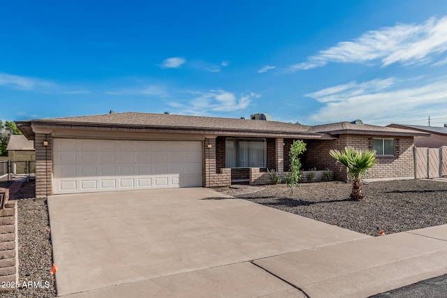 ranch-style house with roof with shingles, driveway, an attached garage, brick siding, and fence