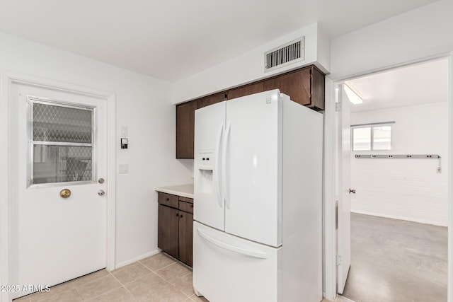 kitchen featuring dark brown cabinets, visible vents, light countertops, and white fridge with ice dispenser