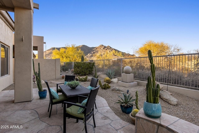 view of patio / terrace featuring outdoor dining area, a fenced backyard, and a mountain view