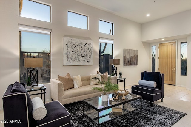 living room featuring recessed lighting, a towering ceiling, and baseboards